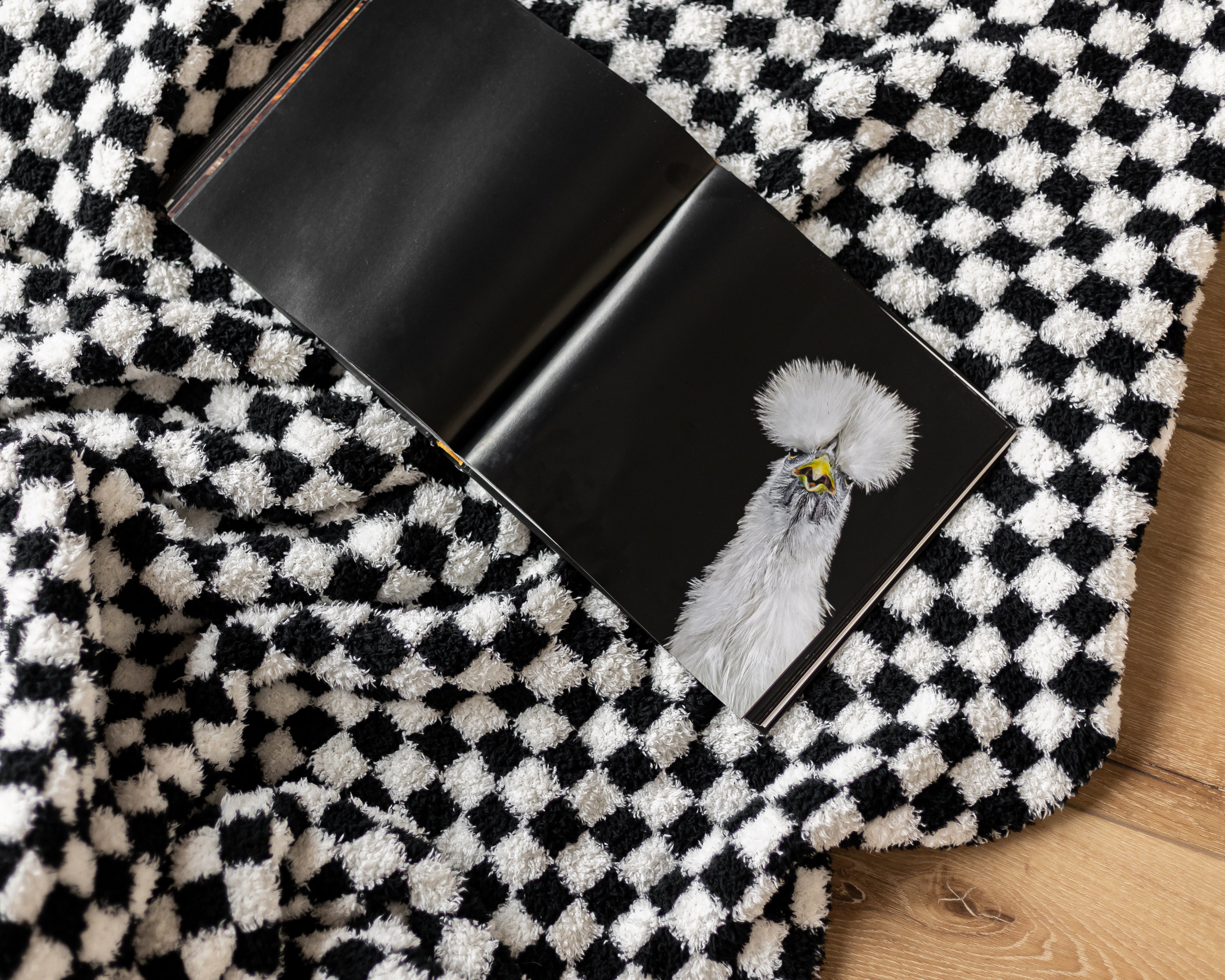 Black wallet with a chicken design on a black and white checkered fabric