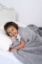 cable knit ultimate grey extended throw blanket on a bed