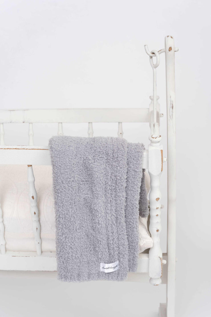 cable knit ultimate grey lovey on a  crib