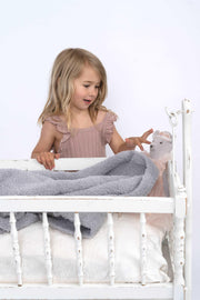 cable knit ultimate grey lovey with little girl playing with a crib