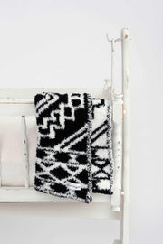 black and white diamond tile lovey baby blanket on a cradle