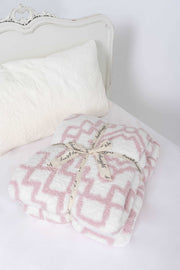 diamond tile rose pink and white twin throw blanket on a bed 
