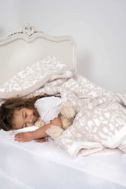 little girl with leopard blushing beige and white extended throw blanket