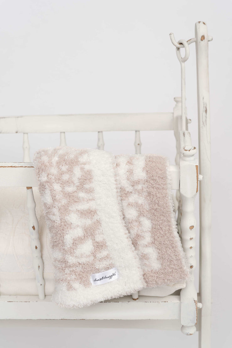 leopard print blushing beige and white lovey on a cradle