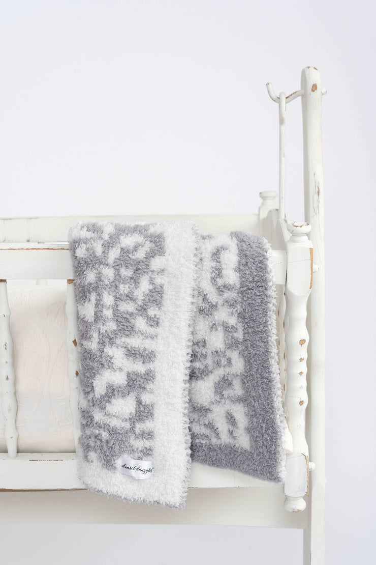 leopard print ultimate grey and cloud white lovey on a cradle