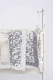 leopard ultimate grey and white toddler baby blanket on a cradle