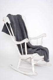 solid ribbed smokey grey throw blanket on a rocking chair
