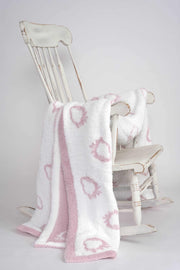 Beautiful soft luxurious plush pink and cream throw blanket on a rocking chair