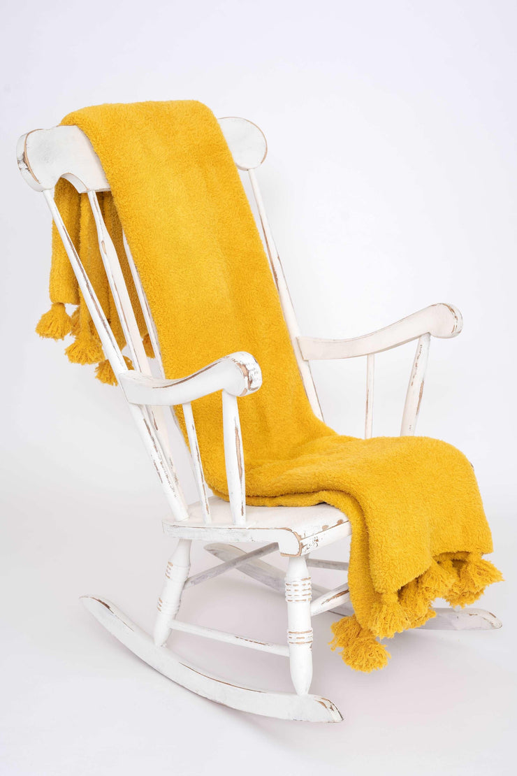 tassel spicy mustard throw blanket on rocking chair